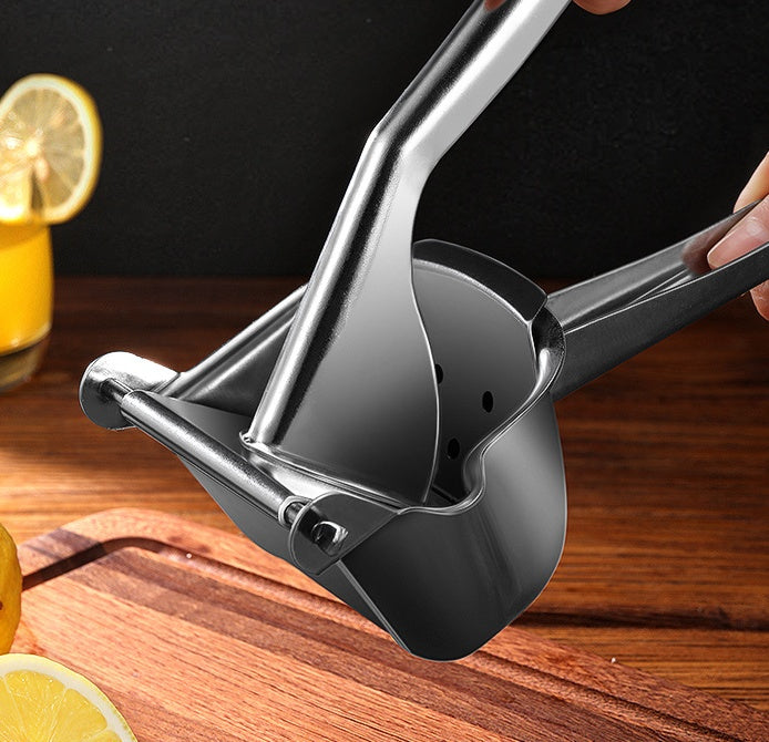 Hand using the Stainless Steel Manual Juice Squeezer to extract juice from an orange.