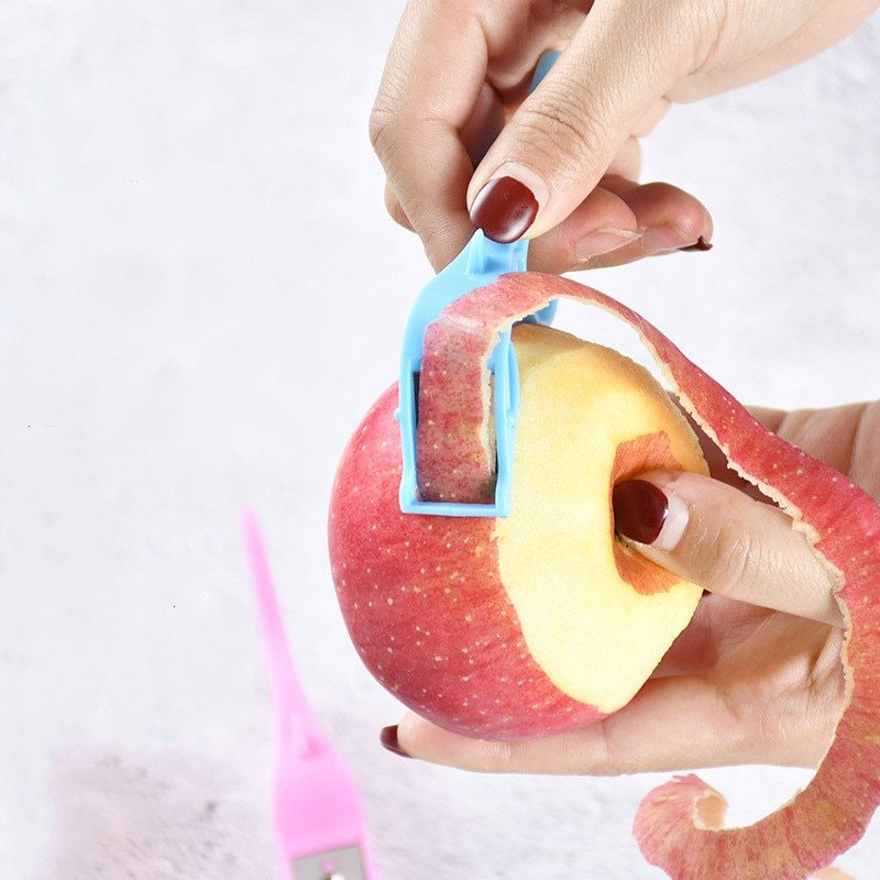 Multifunctional Fruit Peeler in pink, with a close-up of the stainless steel blade